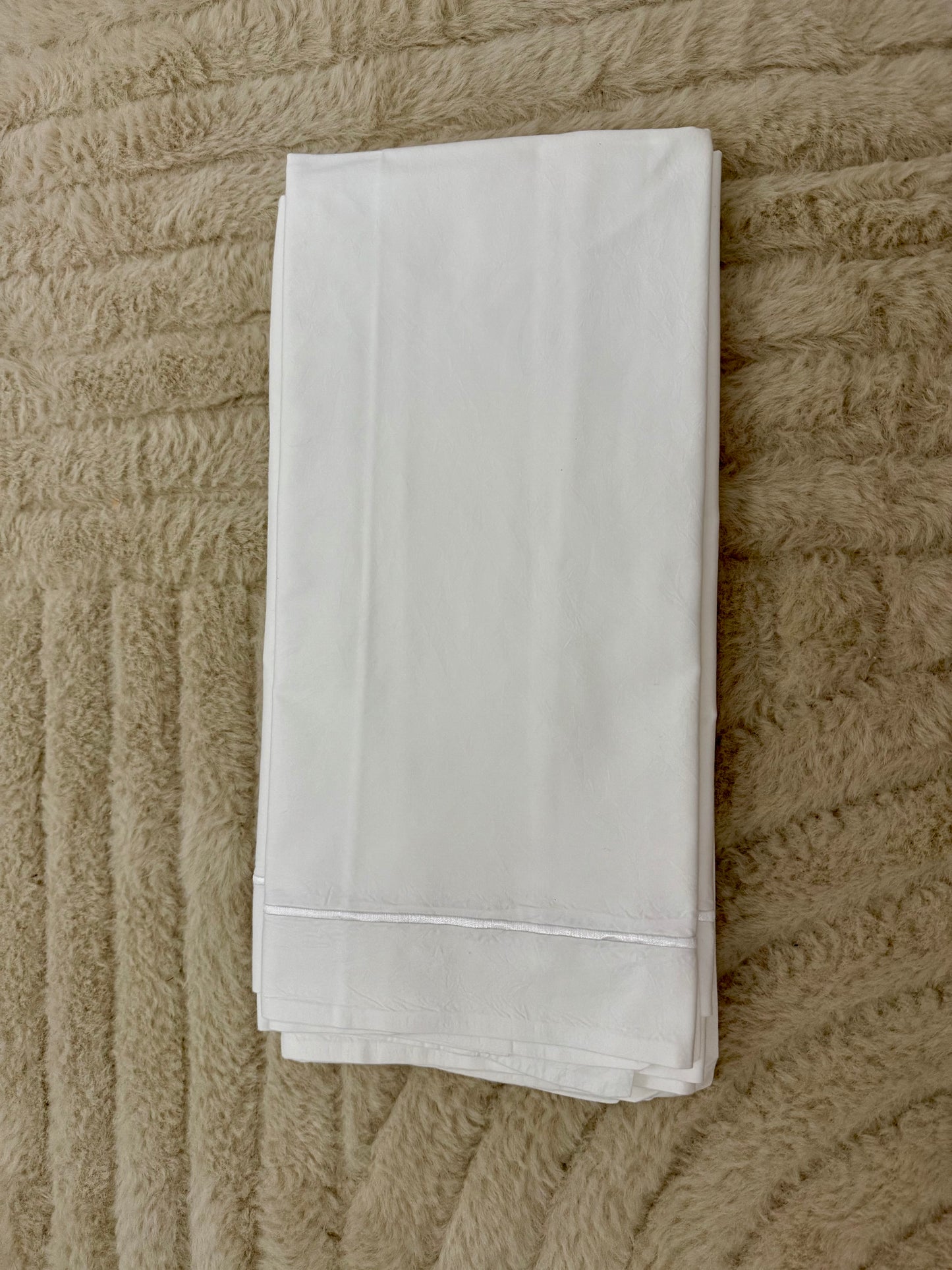 Taie d’oreiller blanche élégante en linge professionnel recyclé, douce et résistante, idéale pour literie haut de gamme.