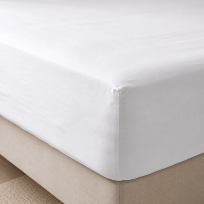 Drap-housse blanc EcoWayve parfaitement ajusté sur un matelas dans une chambre lumineuse au style hôtelier haut de gamme.