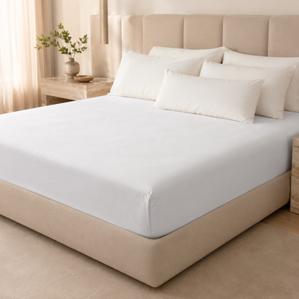 Drap-housse blanc de qualité hôtelière installé sur un grand lit, avec une finition nette et une ambiance lumineuse haut de gamme.