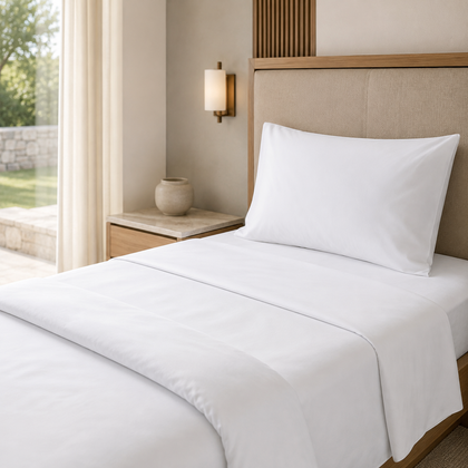 Drap plat blanc professionnel 1 place installe sur un lit simple, dans une chambre lumineuse au style hotelier.