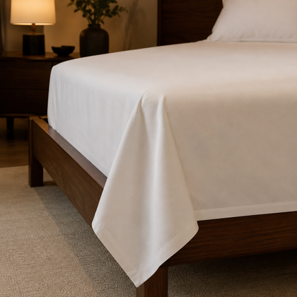 Gros plan sur la retombe et l ourlet d un drap plat blanc professionnel, mettant en valeur la finition textile et la qualite du tissu.