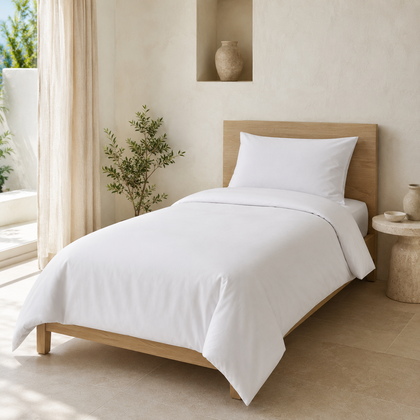 Housse de couette blanche 1 place installee sur un lit dans une chambre lumineuse, avec une presentation soignee inspiree de l hotellerie haut de gamme.