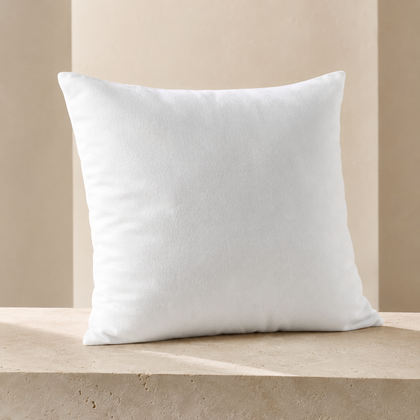 Protège-oreiller blanc en molleton 65 x 65 cm EcoWayve présenté sur un podium en travertin beige.