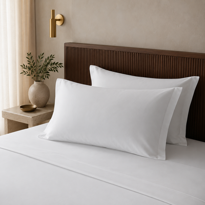 Trois taies d oreiller hotelieres blanches 50x75 cm soigneusement pliees sur une console en pierre, dans une chambre elegante au style haut de gamme.