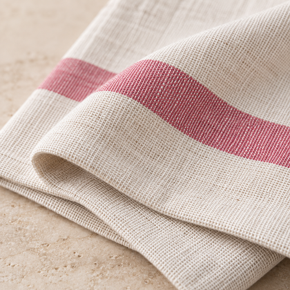 Gros plan sur le tissage en coton et la rayure rose du torchon de cuisine.