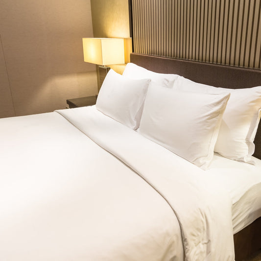 Housse de couette blanche en coton haut de gamme, qualité hôtelière, lit double avec oreillers.
