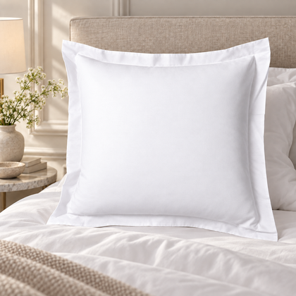 Taie d’oreiller en percale blanche avec volant dans une chambre élégante.